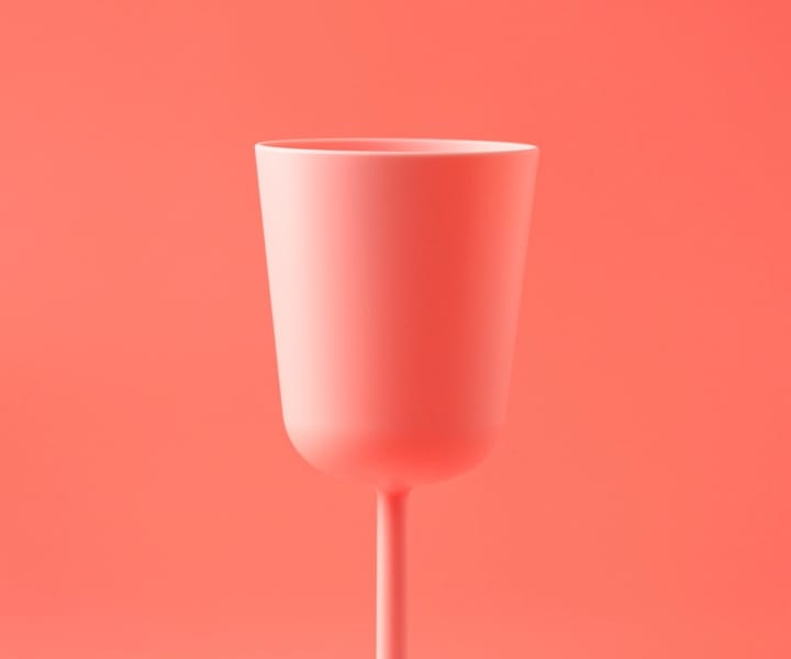 a white glass with pink background